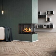 Holz-Kamineinsatz VISIO 3:1 ist als Raumteiler Kamin in einer grünen Wand integriert, welche den Wohnraum strukturiert