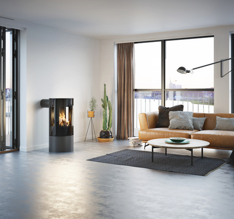 Gas-Kaminofen VIVA 100 L in Platin mit Vollglas-Feuerraumtür in einer minimalistischer Wohnung mit Aussicht auf die Skyline