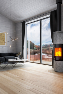 Holz-Kaminofen JUNO 166 L mit Specksteinverkleidung und Vollglas-Feuerraumtür in grossem Wohnzimmer in Grautönen